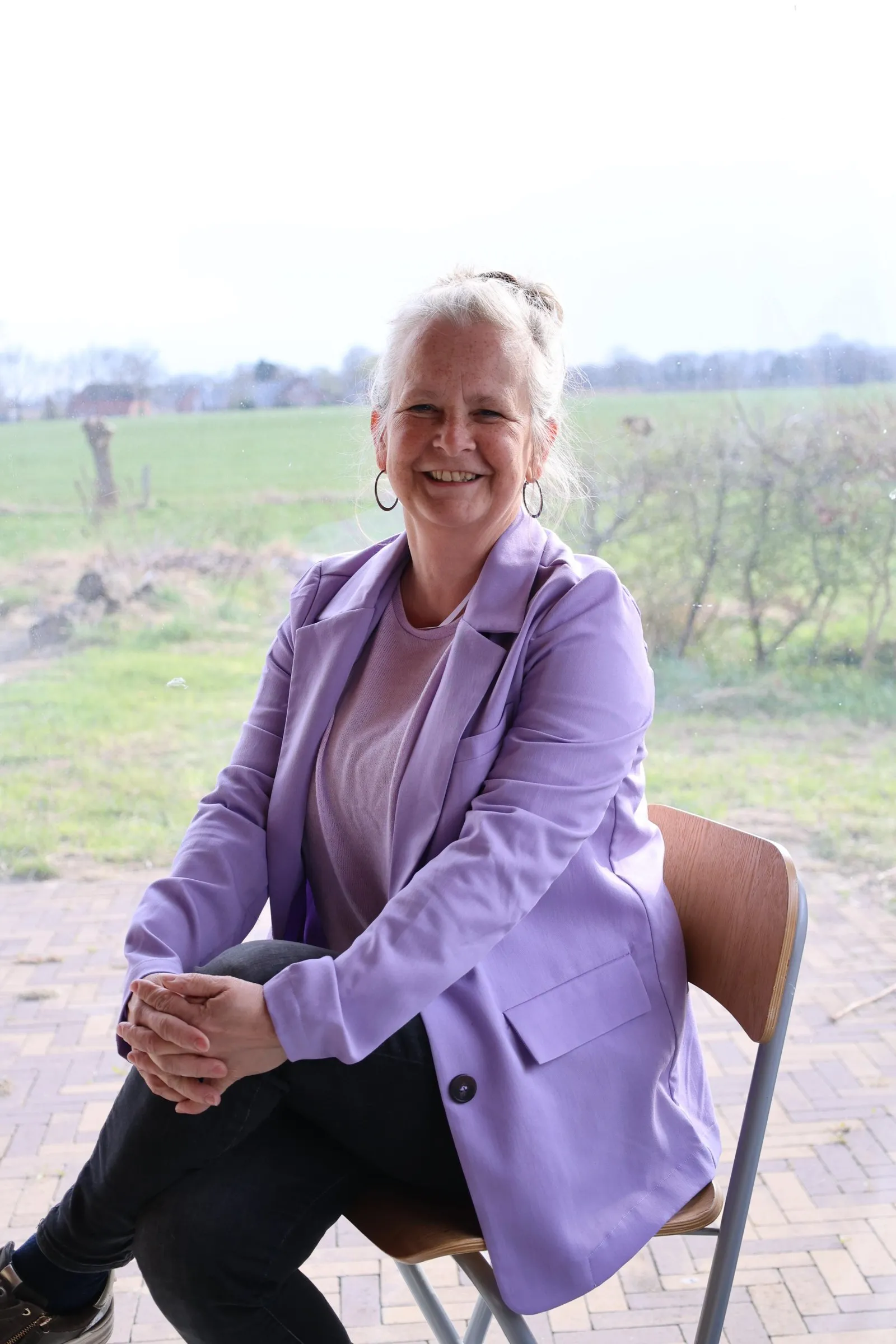 Anita Roskam op een stoel buiten het atelier