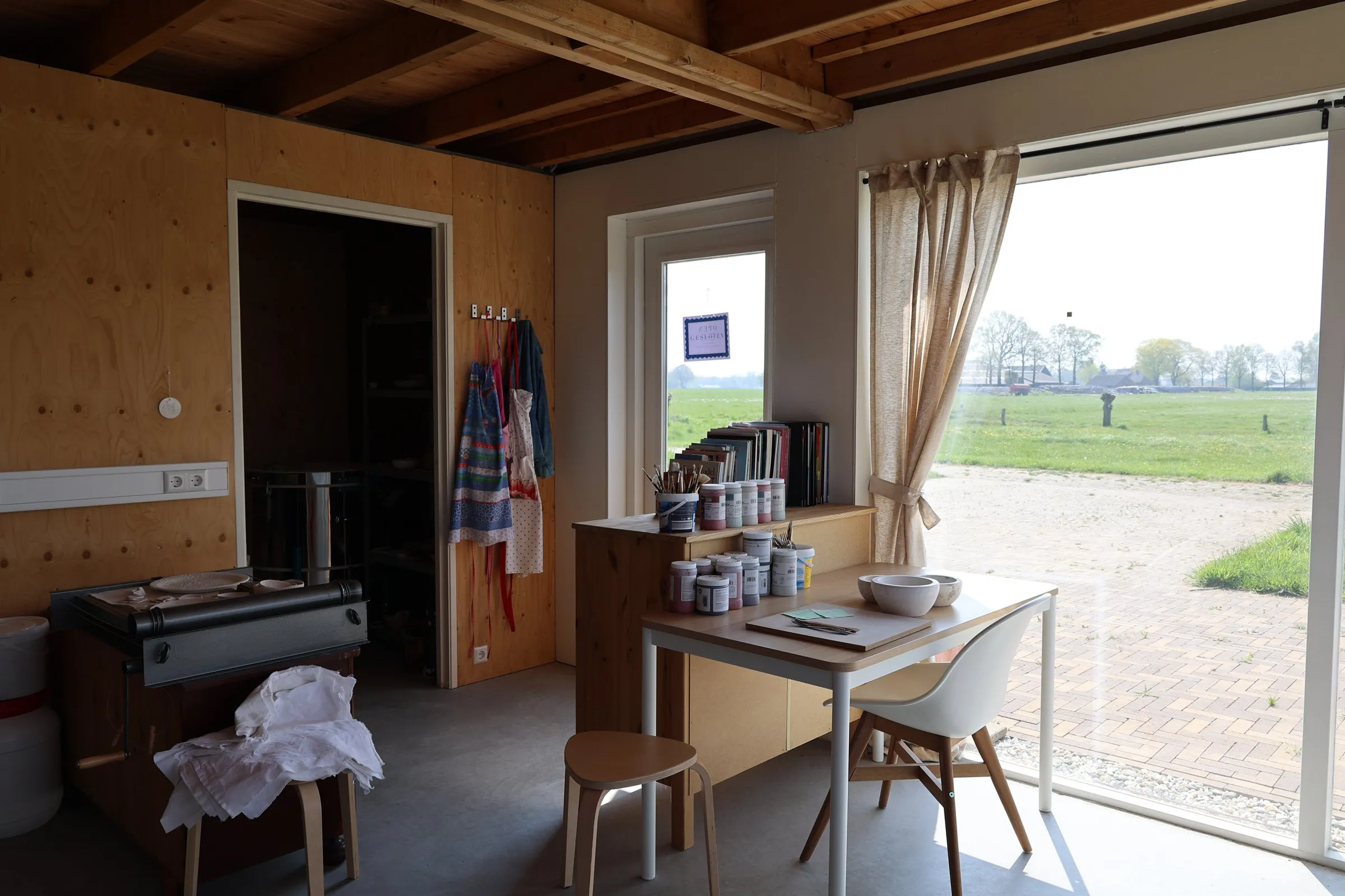Het atelier van binnen, met een open deur naar buiten