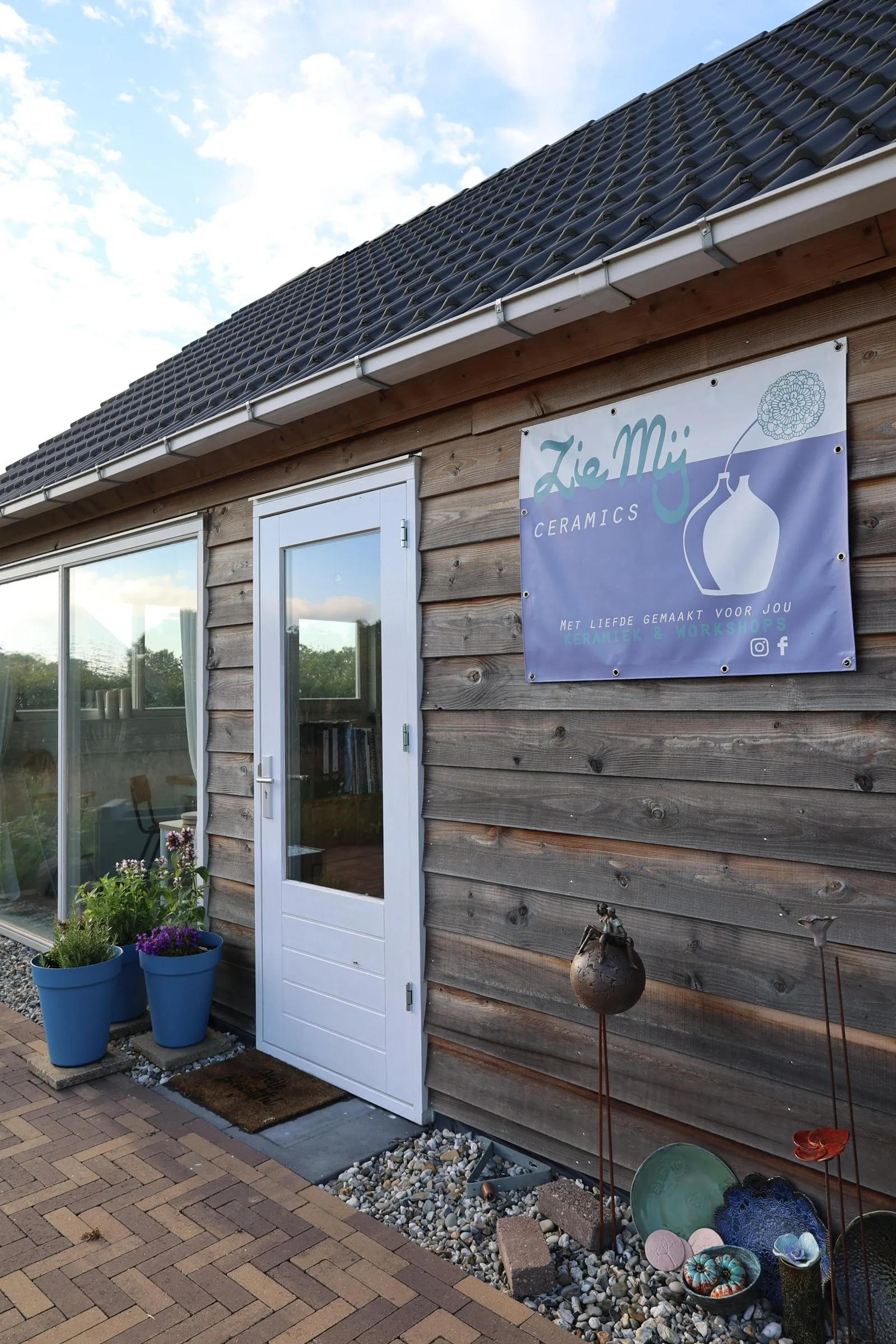De ingang van het atelier met plantenbakken